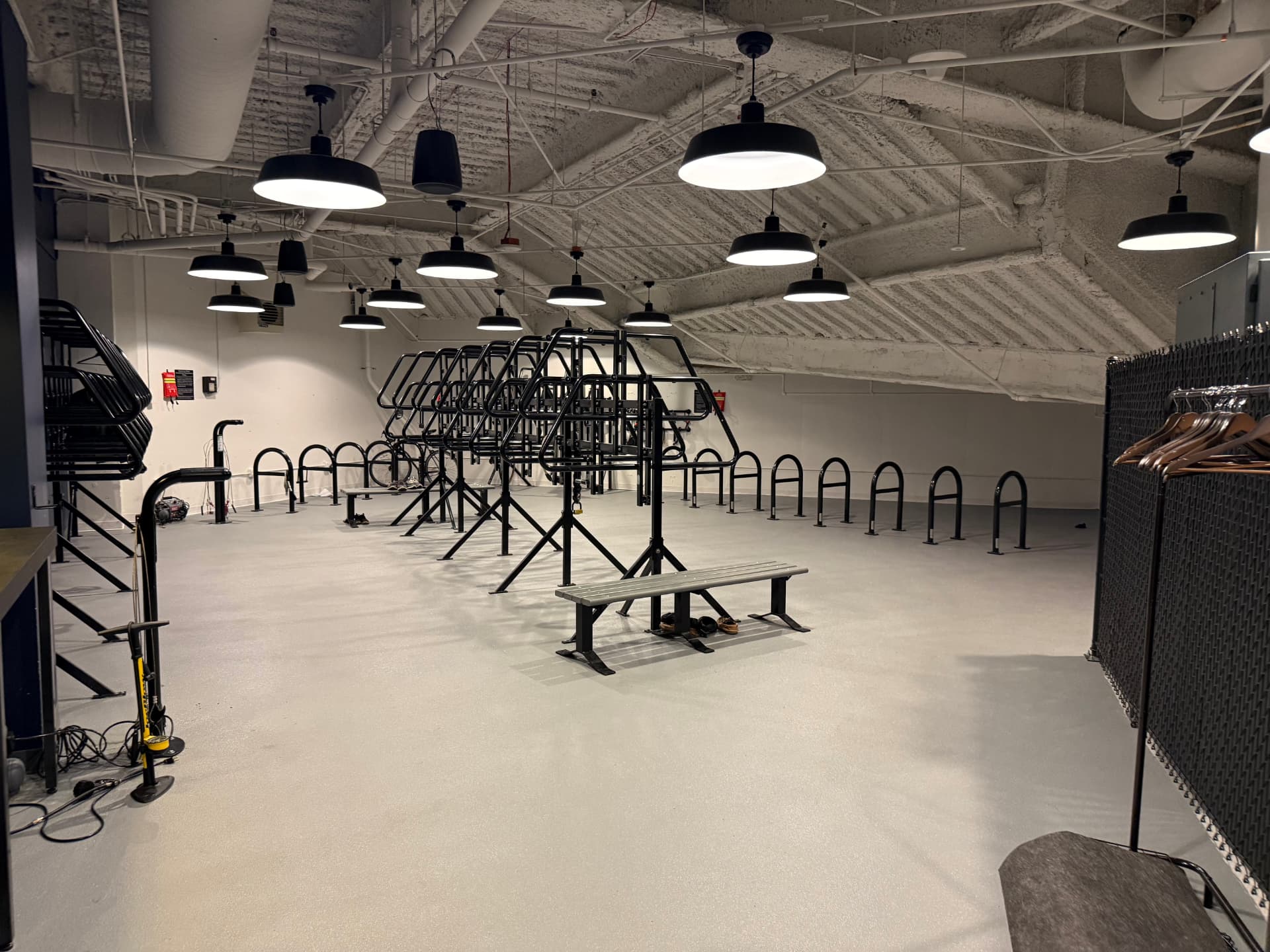 Spacious indoor bike storage room with multiple black metal racks.